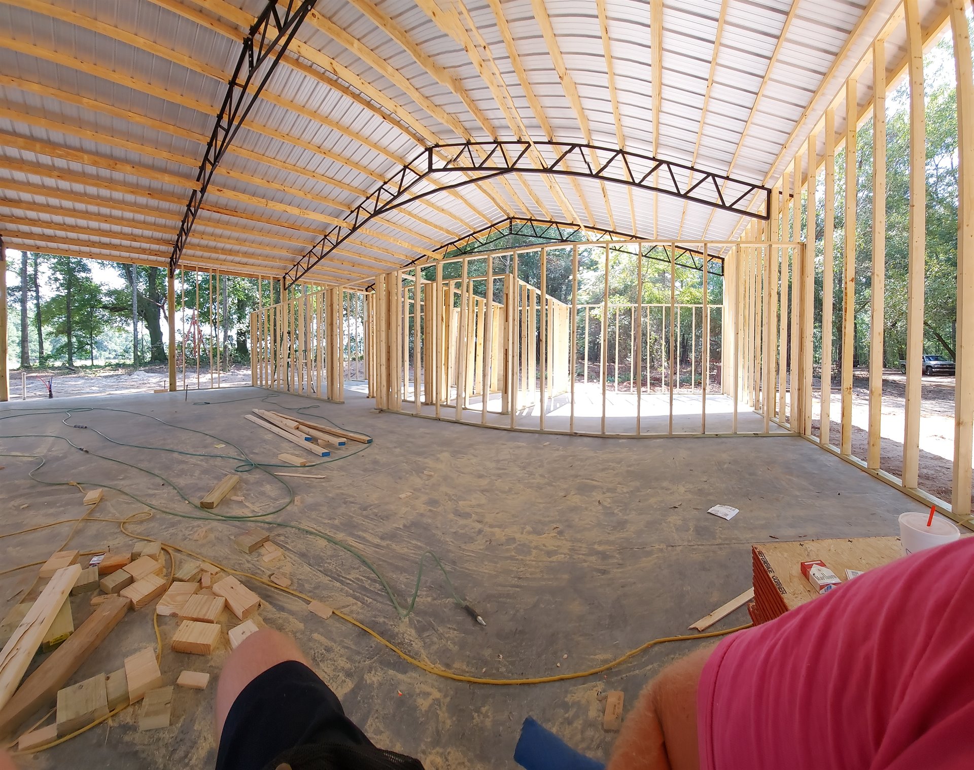 Interior framing beneath a high metal roof during a construction project