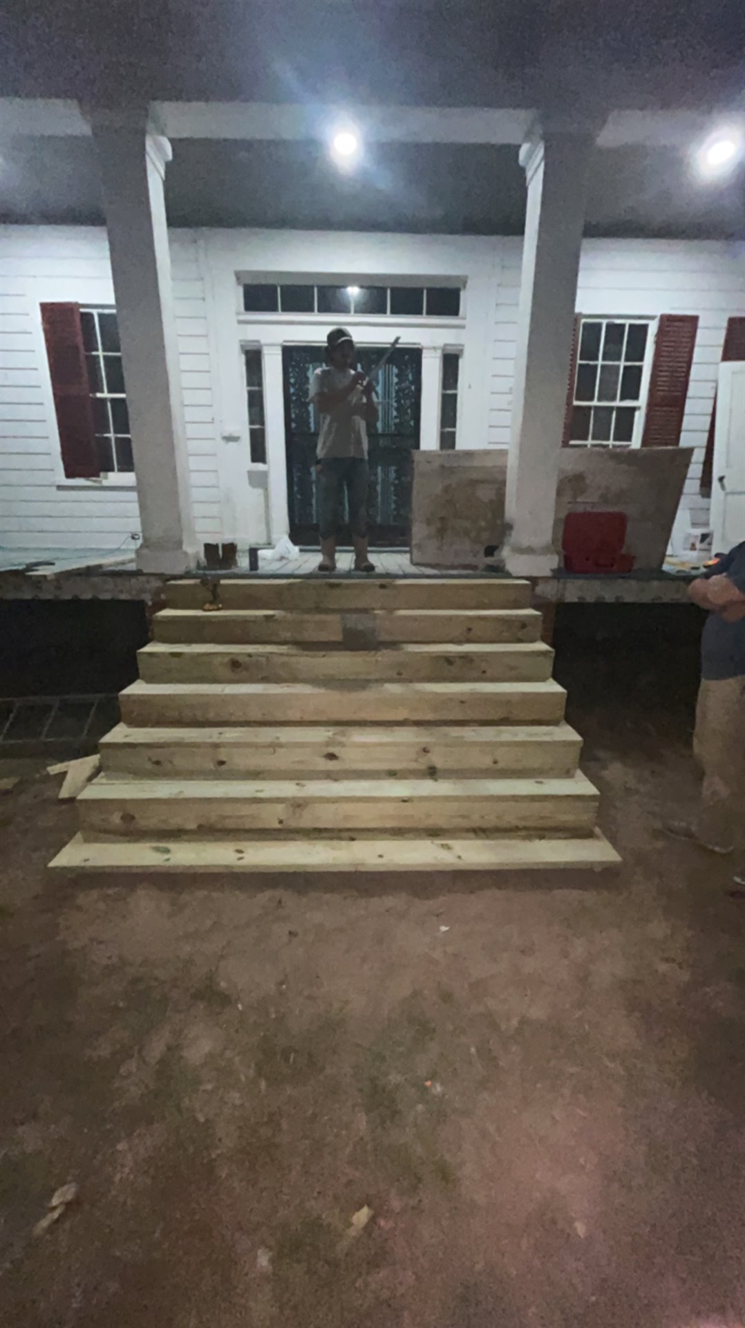 Wide wooden steps leading to a covered home entrance